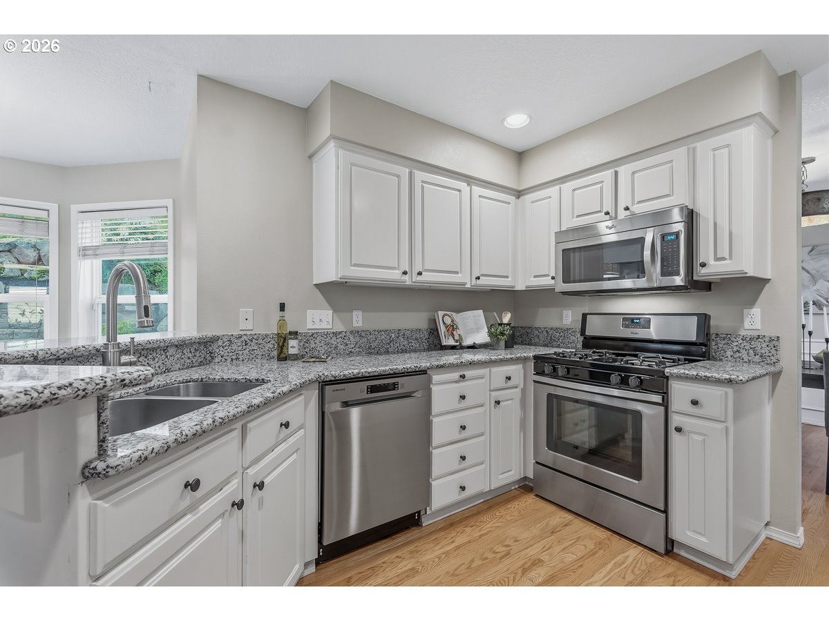 8361 Southwest 168th Avenue Beaverton, OR 97007 - Photo 9 of 31 a kitchen with granite countertop a sink stove and microwave