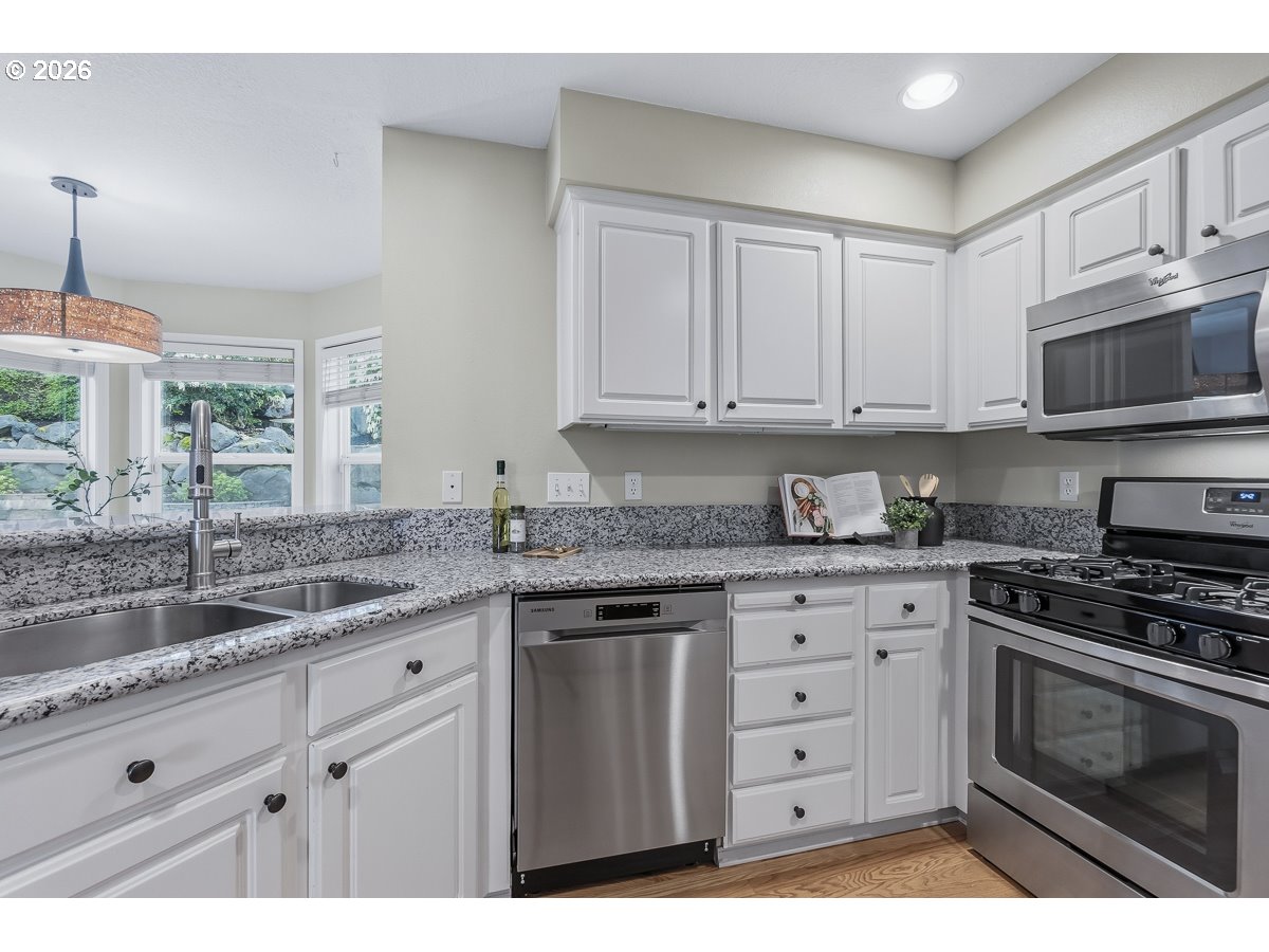 8361 Southwest 168th Avenue Beaverton, OR 97007 - Photo 10 of 31 a kitchen with granite countertop a stove sink and cabinets