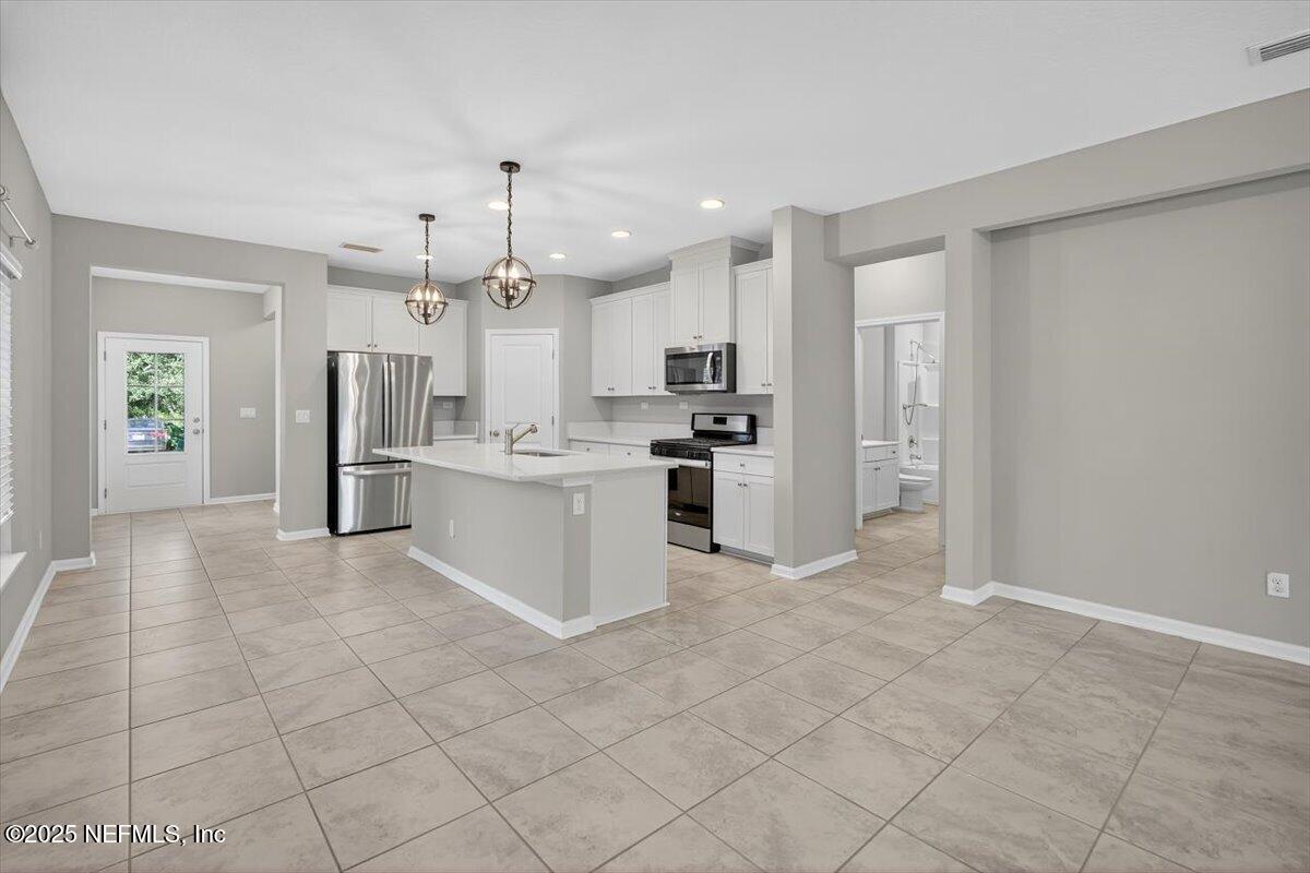 312 Clarys Run St. Augustine, FL 32092 - Photo 14 of 99 a large white kitchen with cabinets and stainless steel appliances