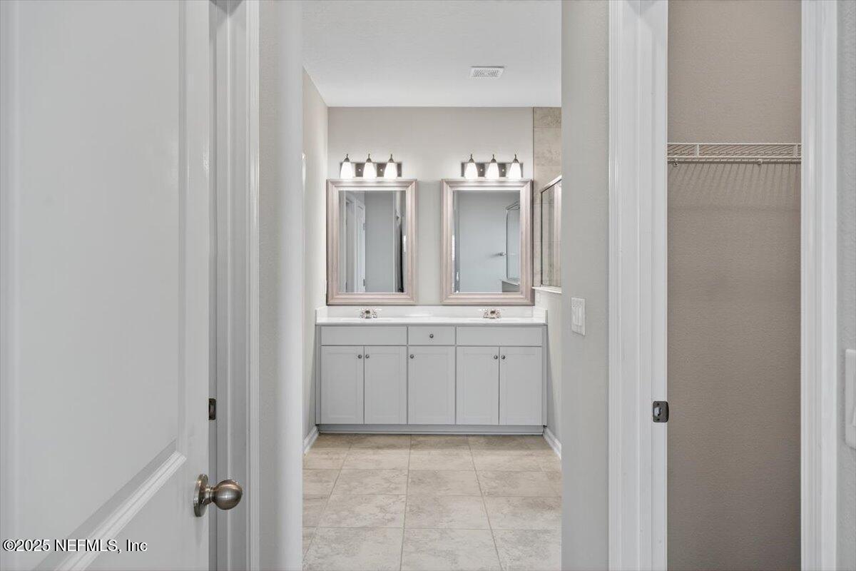 312 Clarys Run St. Augustine, FL 32092 - Photo 28 of 99 a bathroom with a double vanity sink and mirror