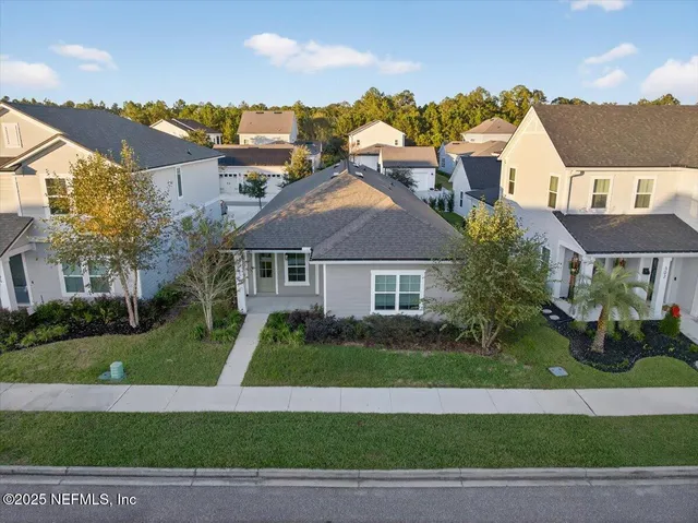 an aerial view of residential houses with outdoor space and lake view