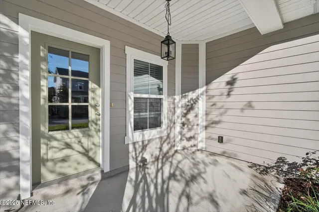 a view of an empty room with window and stairs