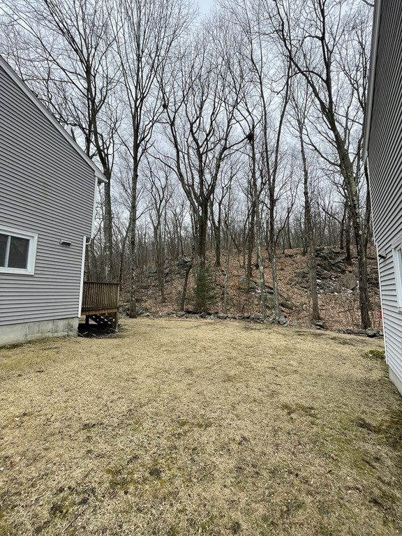 270 Sunderland Road, Unit 76 Worcester, MA 01604 - Photo 4 of 21 a view of a yard with a house and trees covered with snow in front of it