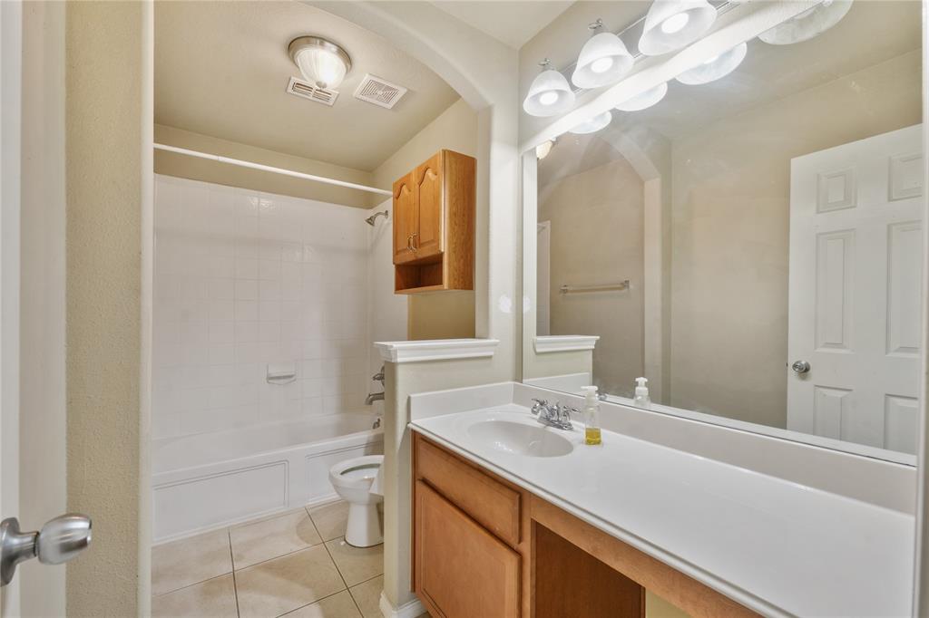 2003 Diamondback Forney, TX 75126 - Photo 23 of 30 Full bathroom featuring vanity with extensive cabinet space, tiled shower / bath, toilet, and tile floors