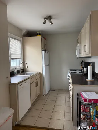 a kitchen with a sink a refrigerator and cabinets