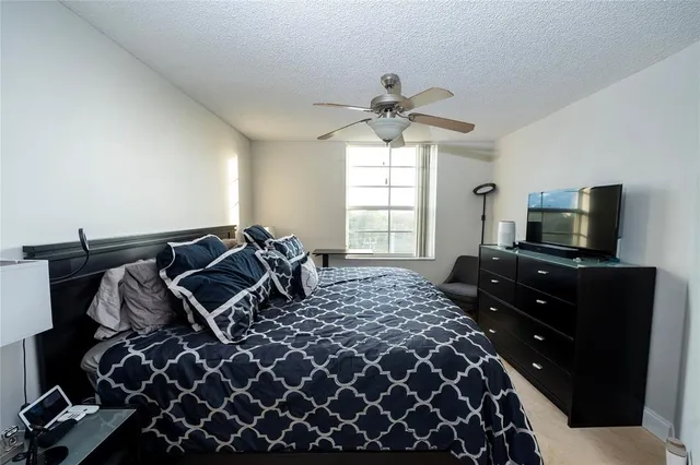 a bedroom with a bed and ceiling fan