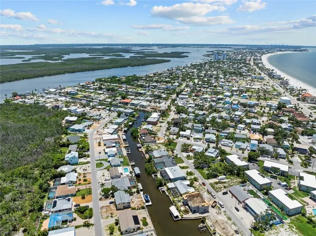 an aerial view of a city with lots of residential buildings and ocean view in back