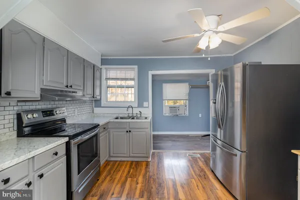 a kitchen with granite countertop stainless steel appliances cabinets a sink and a window