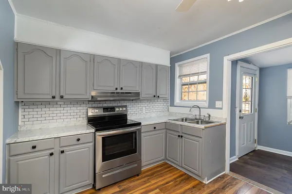 a kitchen with white cabinets stainless steel appliances and sink