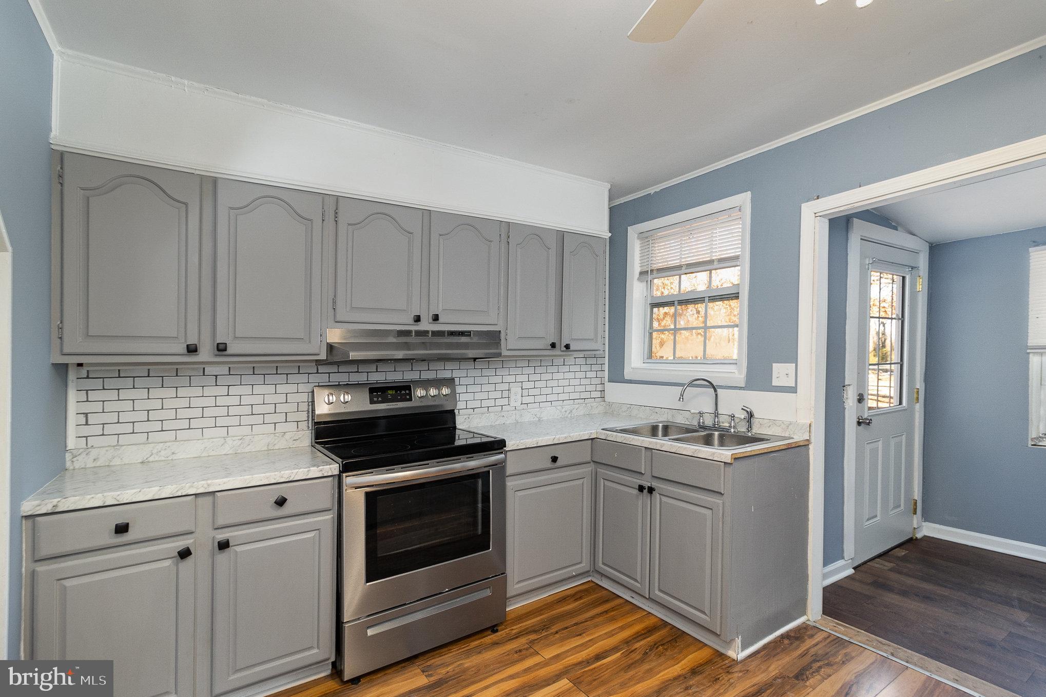 16520 Tomahawk Creek Road Orange, VA 22960 - Photo 15 of 31 a kitchen with white cabinets stainless steel appliances and sink