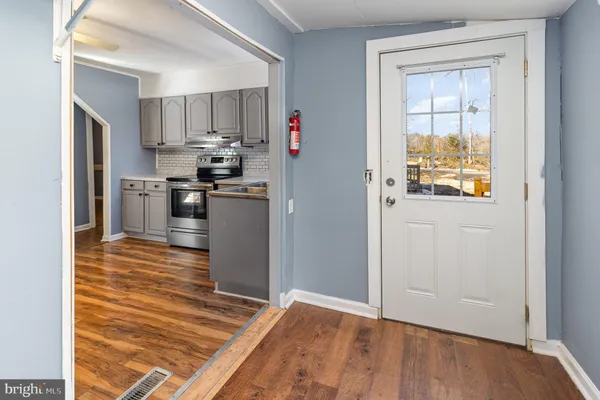 a view of a kitchen with wooden floor and a refrigerator