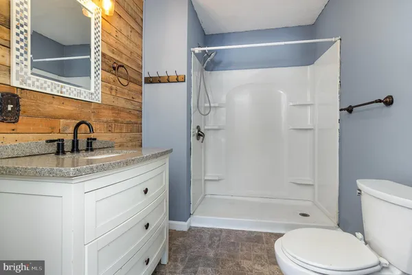 a bathroom with a granite countertop sink toilet and shower