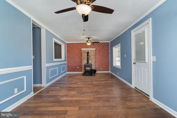 a view of an empty room with chandelier fan and a window
