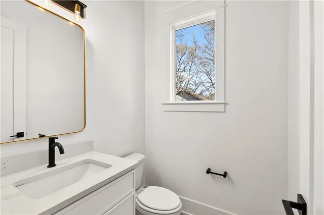 a view of an empty room with wooden floor and a fireplace