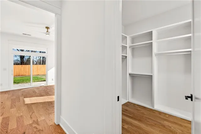 an empty room with windows and ceiling fan
