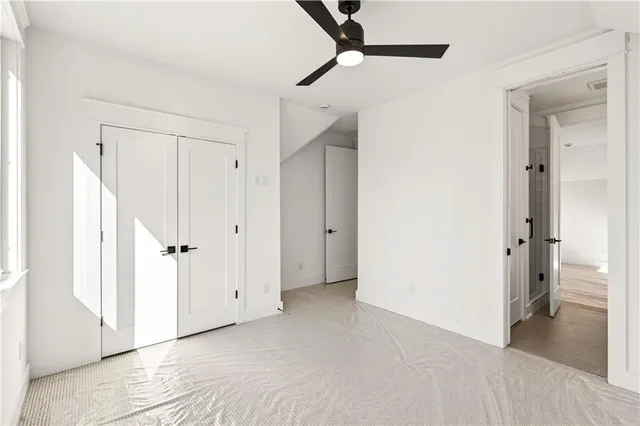 an empty room with a window and a ceiling fan