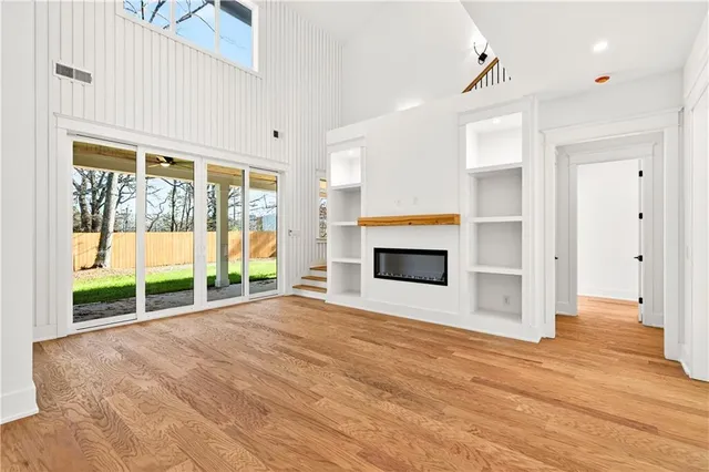 a view of empty room with wooden floor and fireplace
