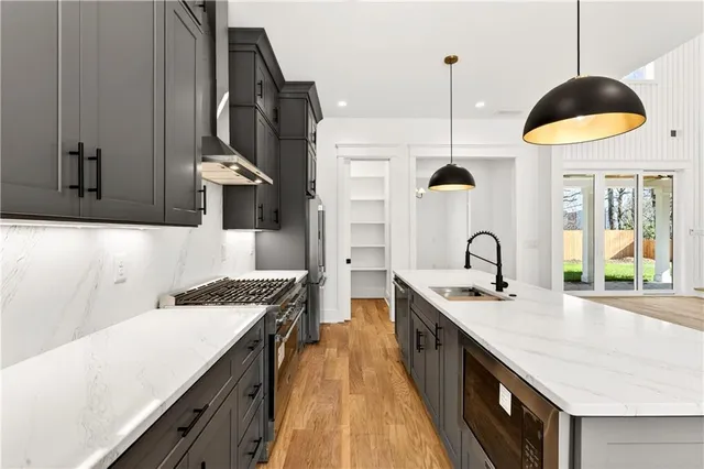 a kitchen with stainless steel appliances a sink a stove and a wooden floors