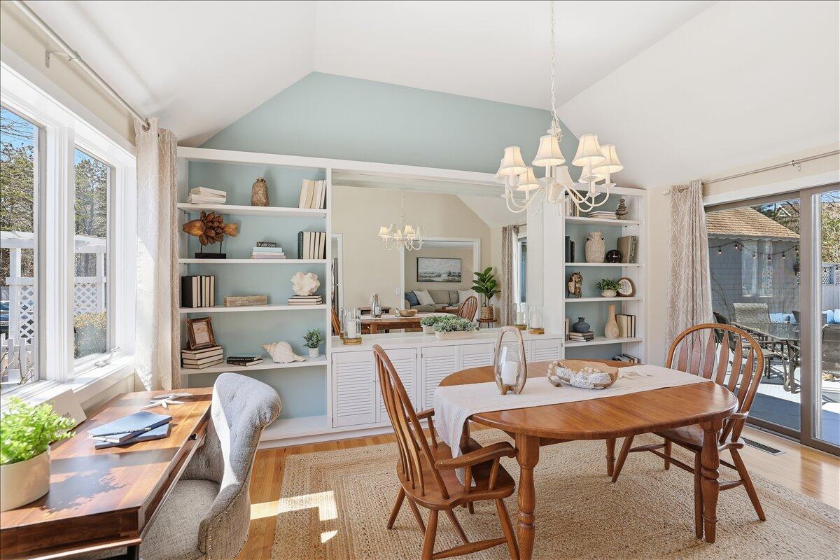 100 Mid-Iron Way, Unit 7027 Mashpee, MA 02649 - Photo 14 of 38 a dining room with furniture a chandelier and wooden floor