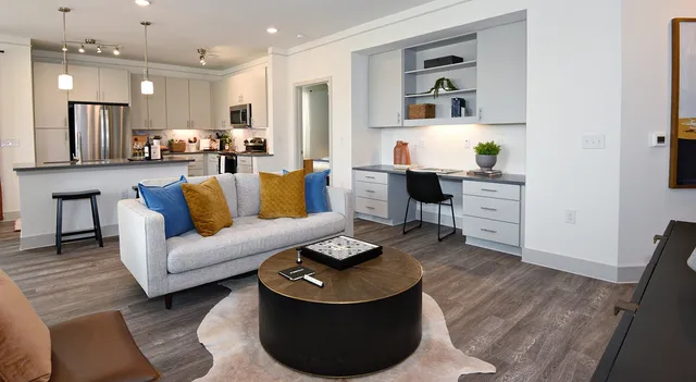 a living room with furniture and a dining table with wooden floor