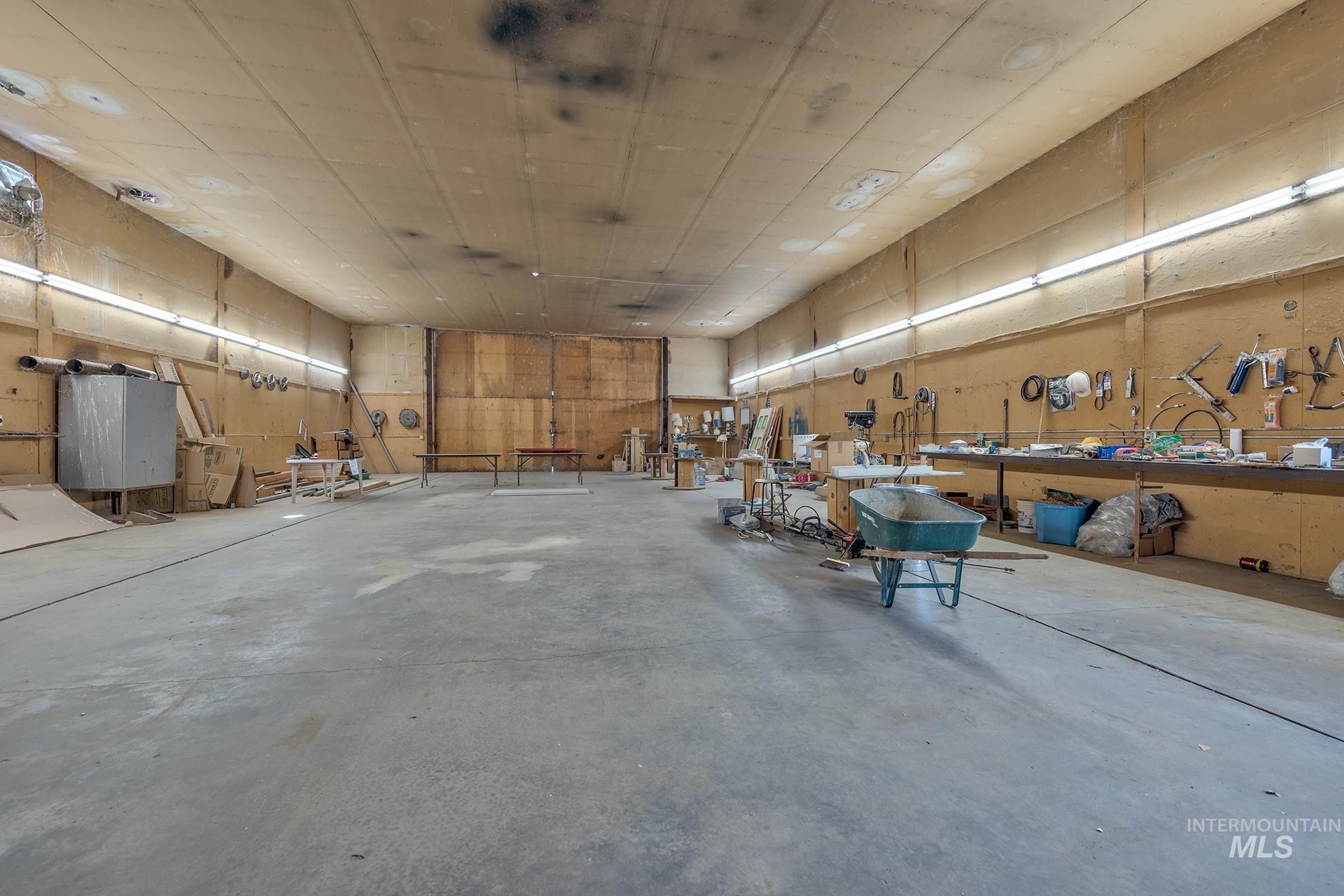 748 Pringle Road Weiser, ID 83672 - Photo 35 of 47 Expansive workshop featuring a concrete floor, plywood walls, and overhead fluorescent lighting
