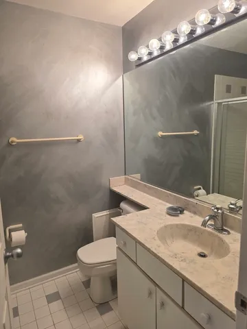 a bathroom with a sink a toilet a mirror and shower