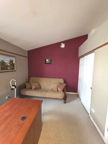 a view of a hallway with furniture and wooden floor