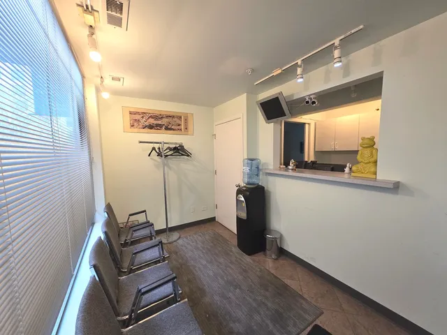 a view of a workspace with furniture and a window