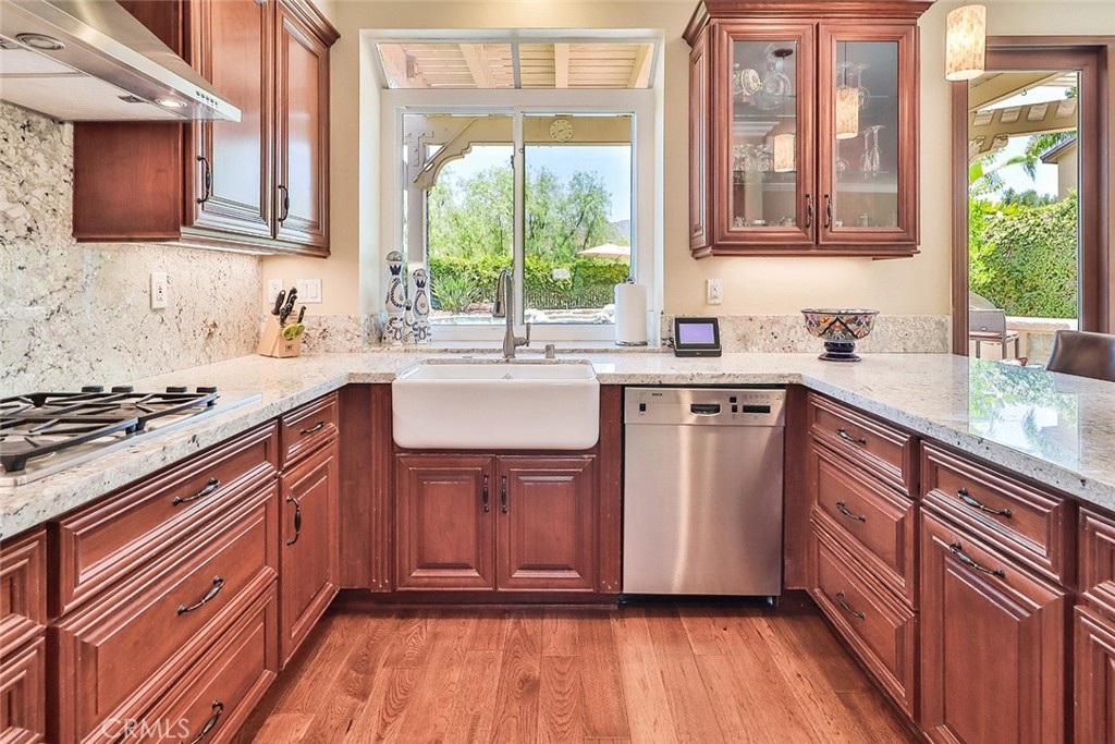 5205 Pesto Way Oak Park, CA 91377 - Photo 21 of 71 a kitchen with stainless steel appliances granite countertop wooden cabinets a sink and a stove