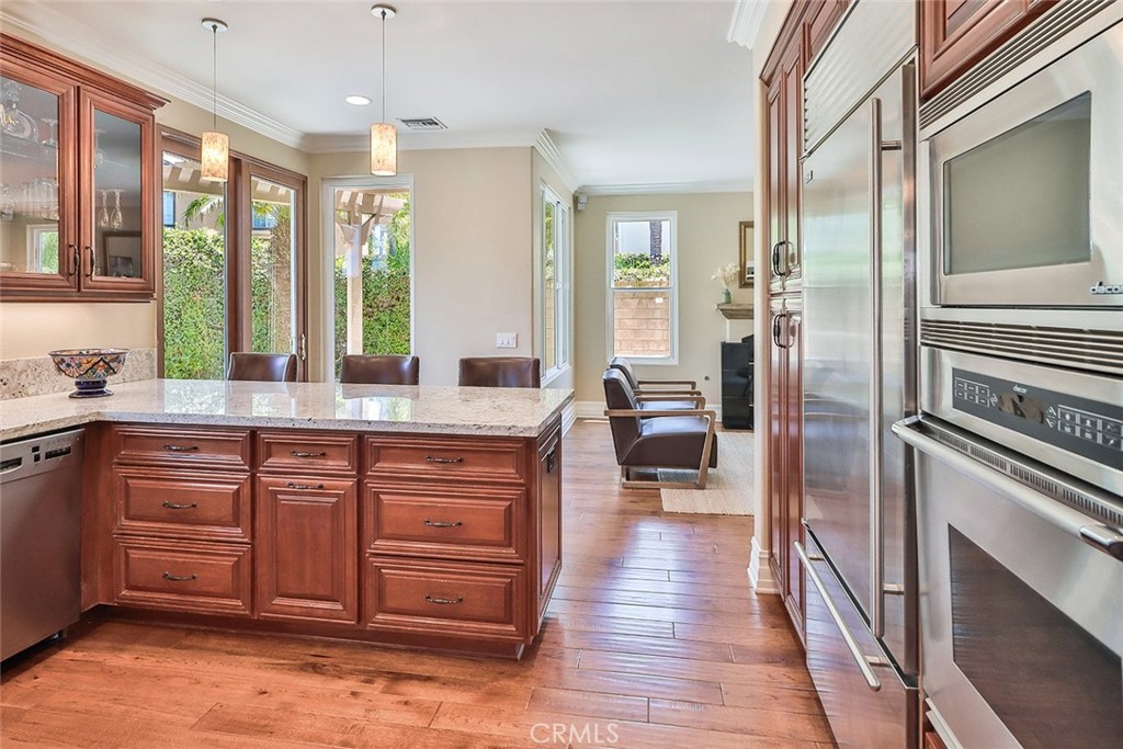 5205 Pesto Way Oak Park, CA 91377 - Photo 26 of 71 a kitchen with stainless steel appliances granite countertop a refrigerator a sink dishwasher a stove and white countertops with wooden floor