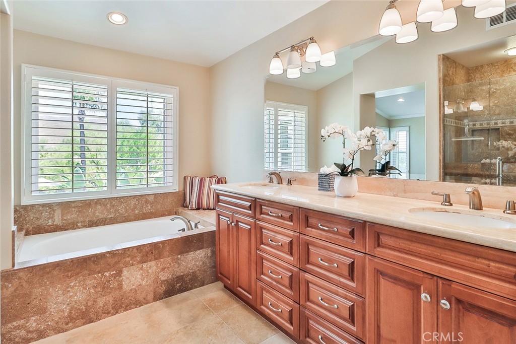 5205 Pesto Way Oak Park, CA 91377 - Photo 37 of 71 a spacious bathroom with double vanity a window a bathtub and a mirror