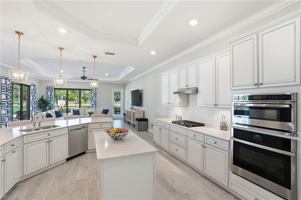2235 Somerset Place Naples, FL 34120 - Photo 48 of 49 a kitchen with stainless steel appliances a stove sink microwave and cabinets