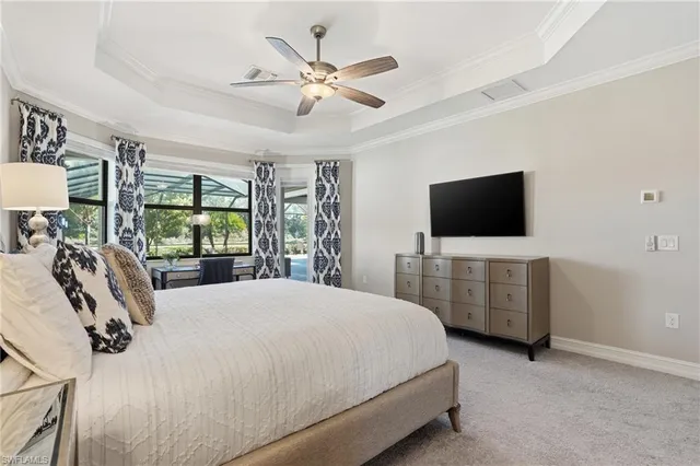 a bedroom with a bed tv and a window