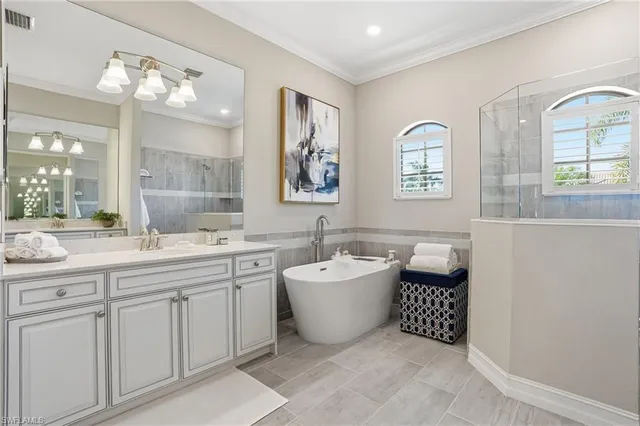 a spacious bathroom with a double vanity sink mirror and bathtub