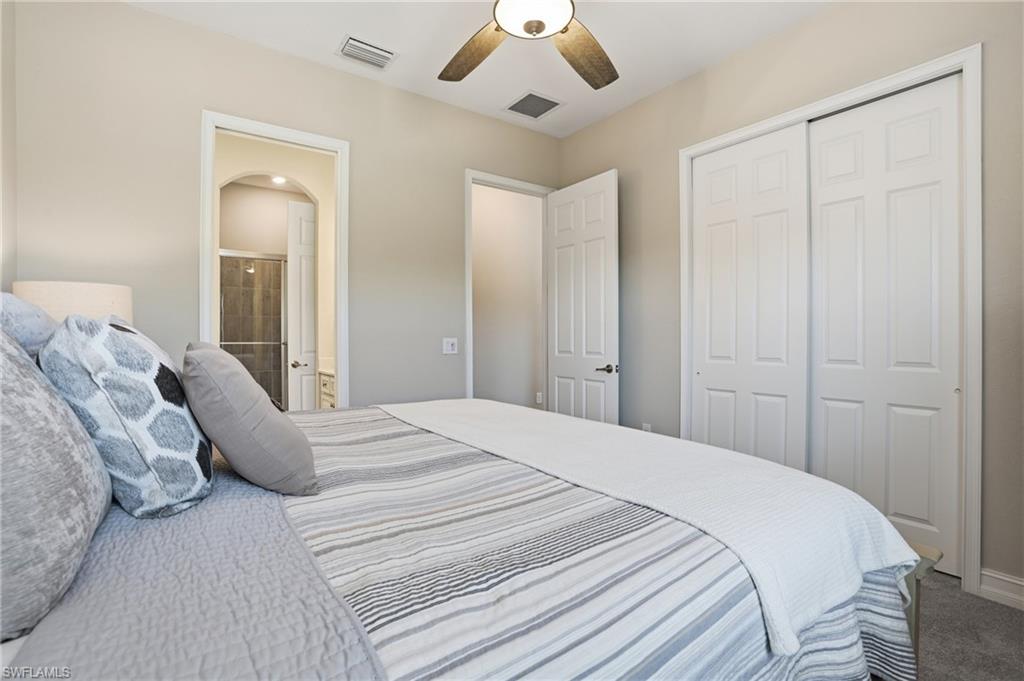 2235 Somerset Place Naples, FL 34120 - Photo 25 of 49 a bedroom with a bed and a chandelier