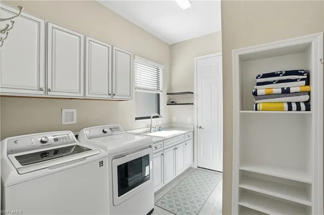 a view of washer and dryer with kitchen in the background