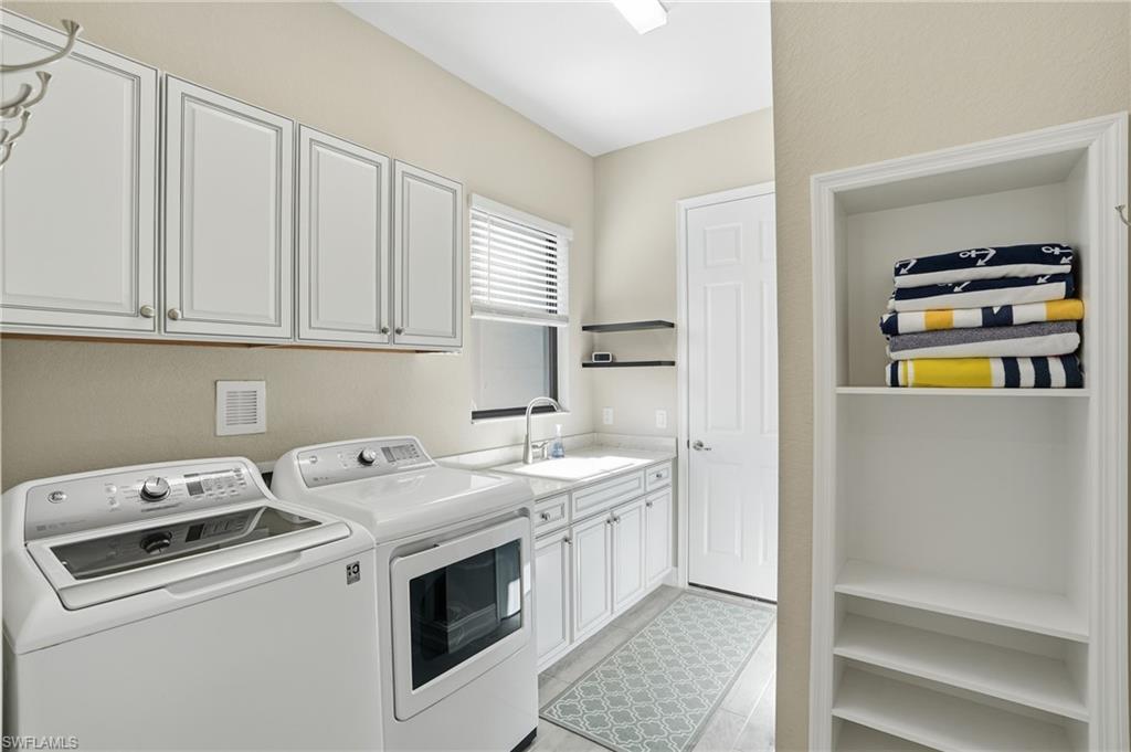 2235 Somerset Place Naples, FL 34120 - Photo 29 of 49 a view of washer and dryer with kitchen in the background