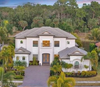 a aerial view of a house with a yard and large tree