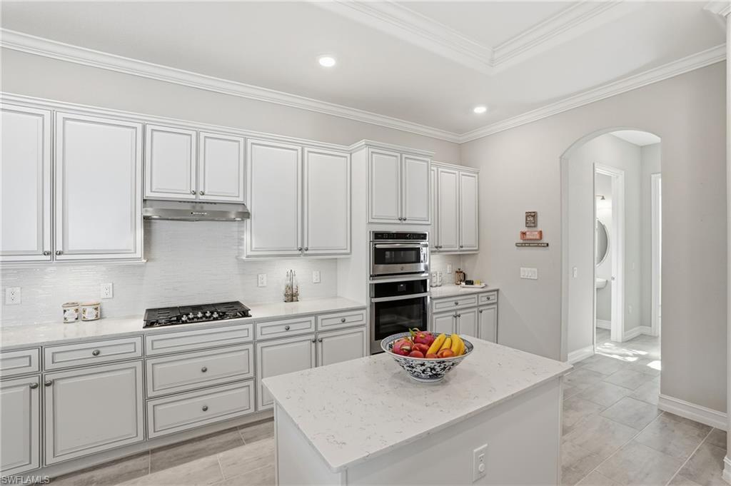 2235 Somerset Place Naples, FL 34120 - Photo 5 of 49 a kitchen with stainless steel appliances a stove a refrigerator and cabinets