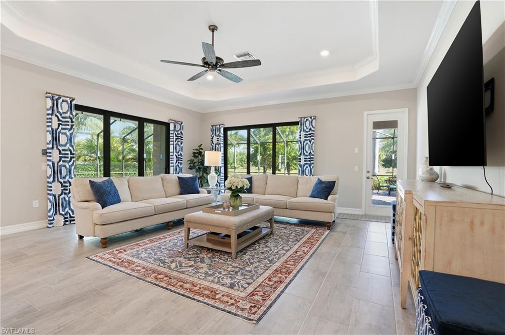 2235 Somerset Place Naples, FL 34120 - Photo 10 of 49 a living room with furniture a flat screen tv and a rug