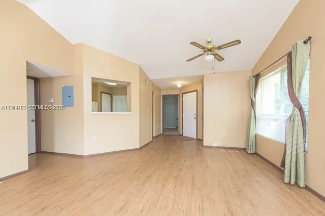a view of a livingroom with wooden floor and a ceiling fan