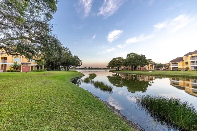 a view of a house next to a lake with a big yard