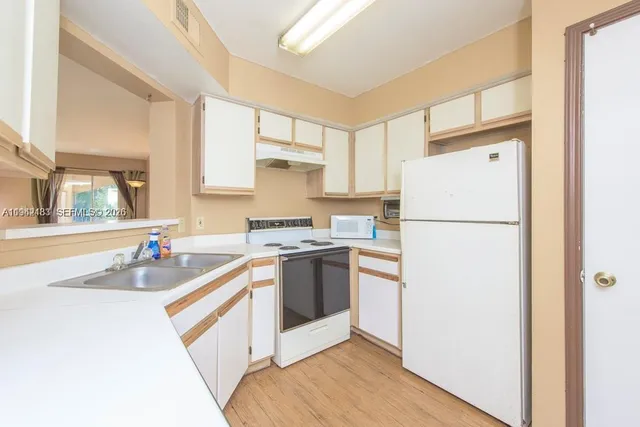 a kitchen with a refrigerator and a sink