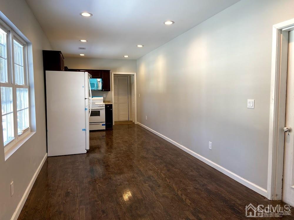 55 Devon Road, Unit A Colonia, NJ 07067 - Photo 4 of 10 an empty room with wooden floor and window