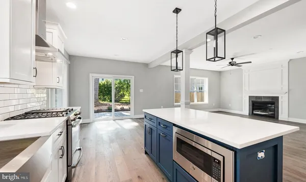a kitchen that has a sink a stove and a wooden floor