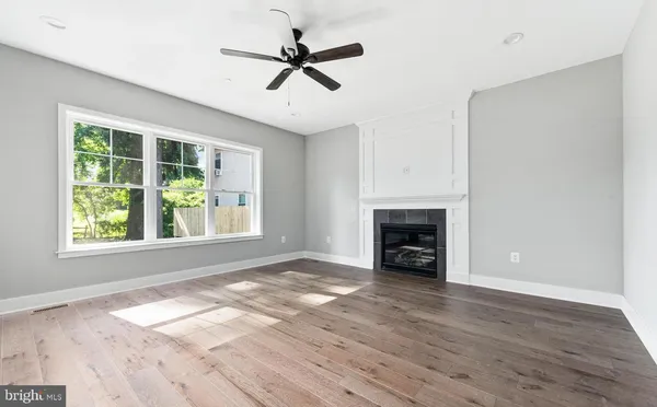 a view of an empty room with a window and fireplace