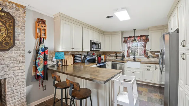 a kitchen with stainless steel appliances kitchen island granite countertop a stove top oven a sink and cabinets