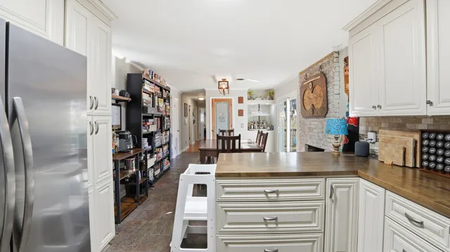 a view of a kitchen with stainless steel appliances granite countertop a refrigerator and a counter space