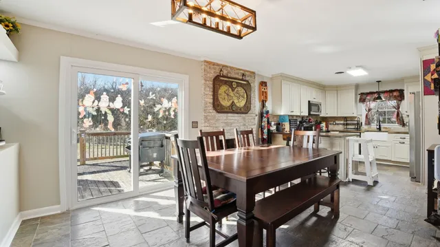a dining room with furniture and a floor to ceiling window