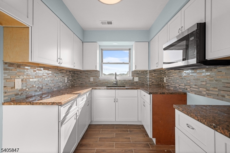 219 Clinton Place Newark, NJ 07112 - Photo 3 of 21 a kitchen with granite countertop sink stainless steel appliances and cabinets